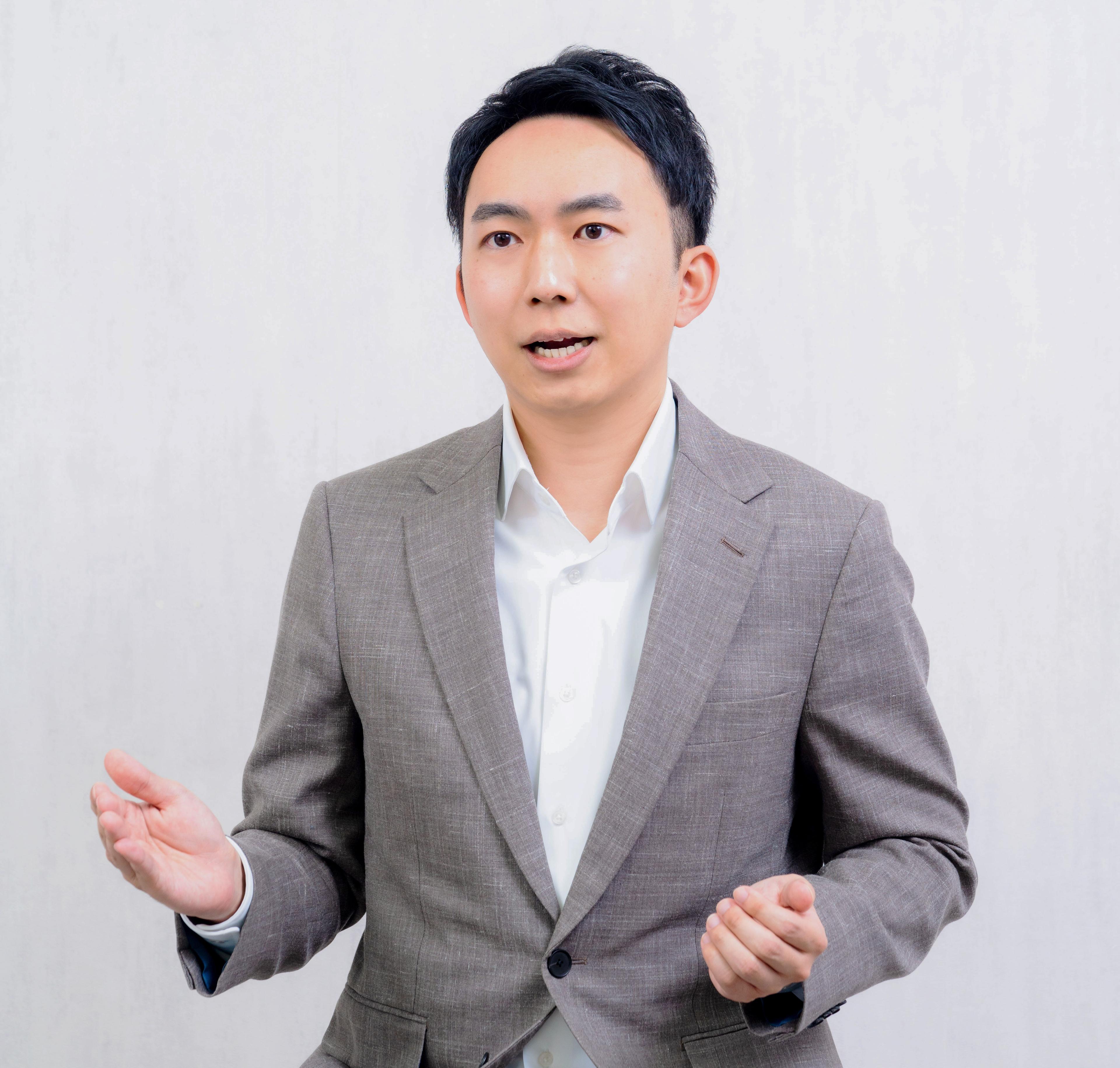ベージュのジャケットで話す宮本直樹